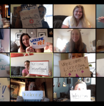 Virtual welcome for summer interns wit people holding signs on a Zoom eeting