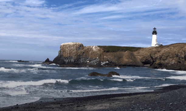 Vacation image showing the Atlantic coast with a lighthouse in the distance